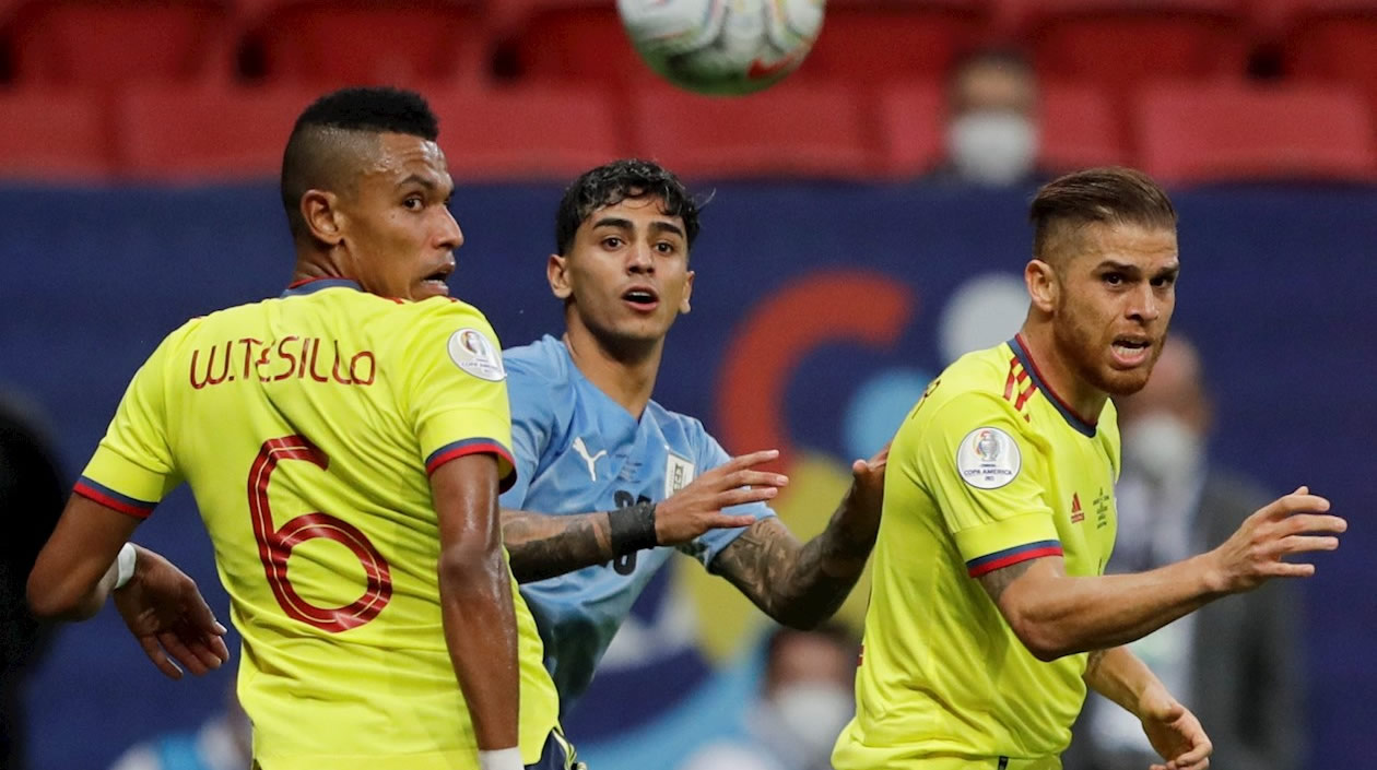 Facundo Torres de Uruguay disputa  el balón con William Tesillo.