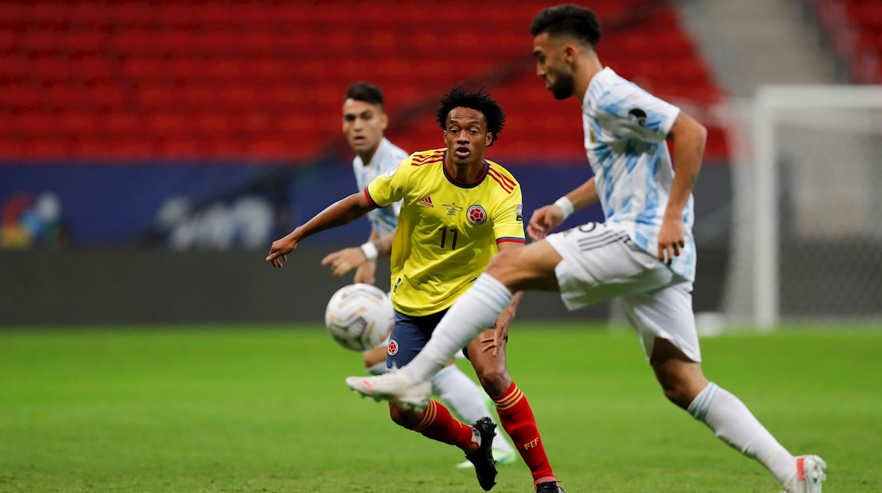 Nicolás González disputando el balón con Juan Guillermo Cuadrado.