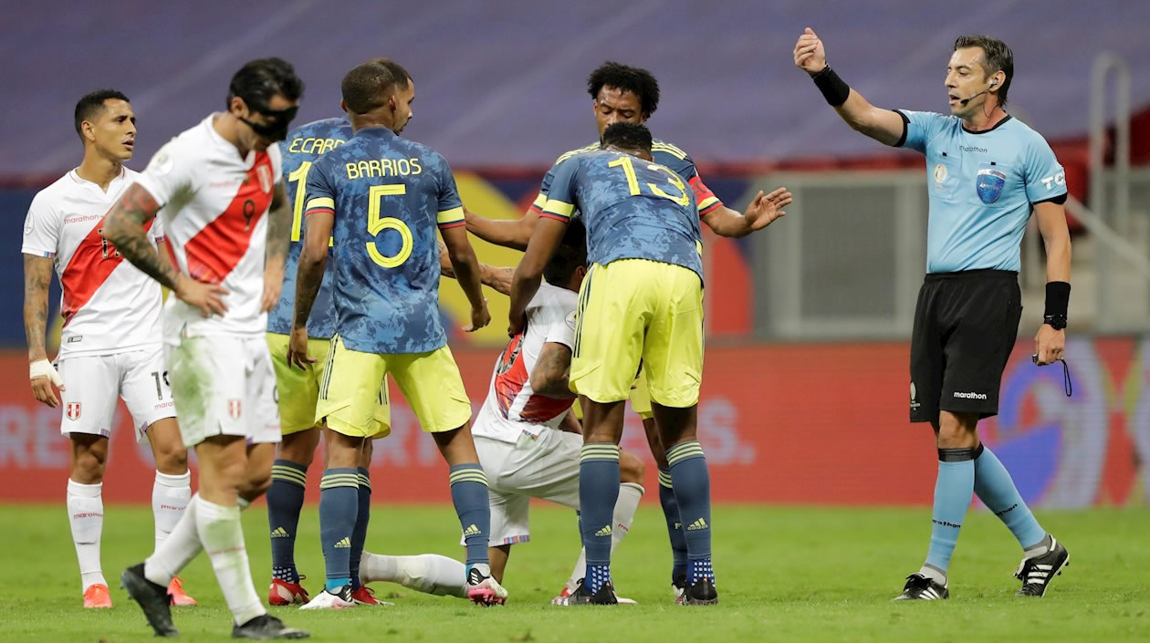 El árbitro Raphael Claus habla con jugadores de Perú y de Colombia