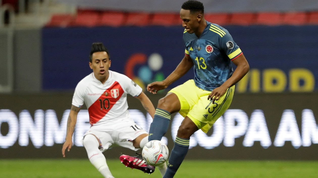 Yerry Mina de Colombia disputa el balón con Christian Cueva