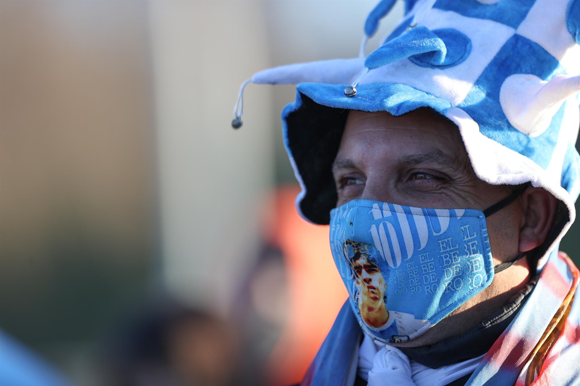 Un hincha argentino con tapabocas de Diego Maradona. 