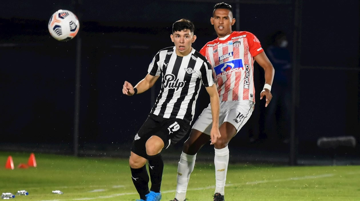 Julio Enciso de Libertad disputando el balón con Homer Martínez.