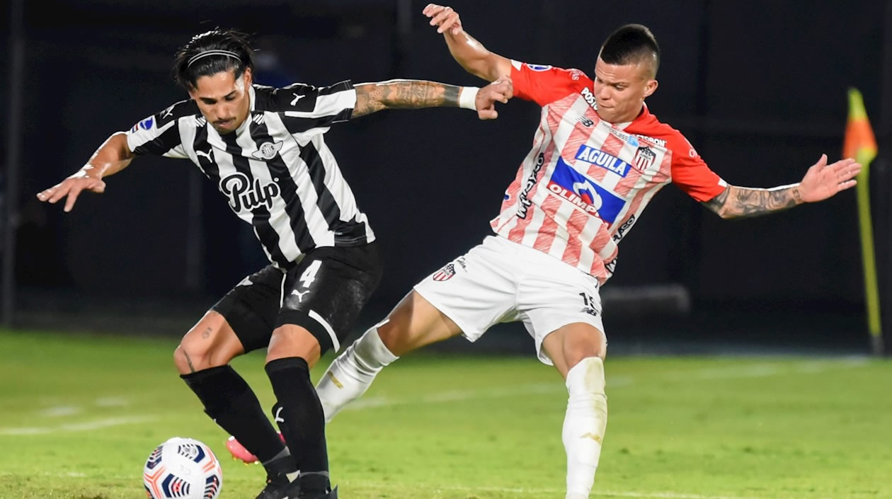 Carlos Cougo intentando superar al lateral juniorista  Walmer Pacheco