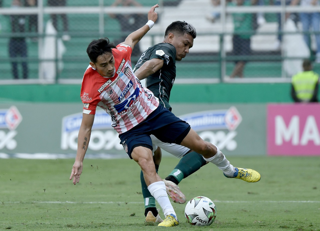 Fabián Sambueza disputando el balón con Teófilo Gutiérrez.