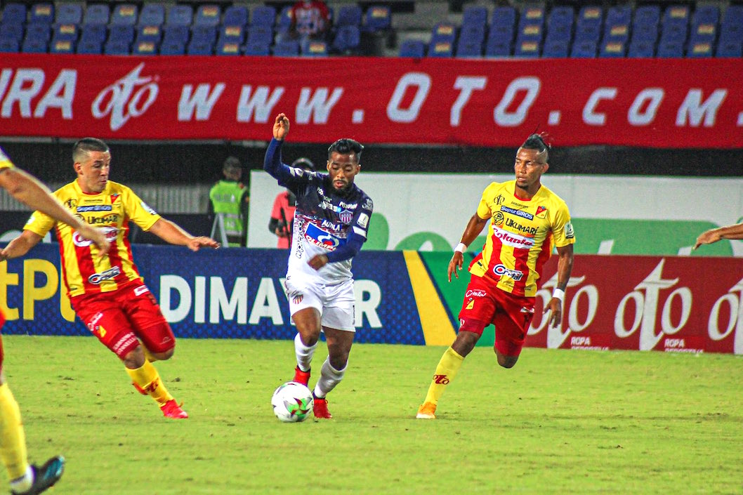 Luis 'Cariaco' González eludiendo a dos rivales.