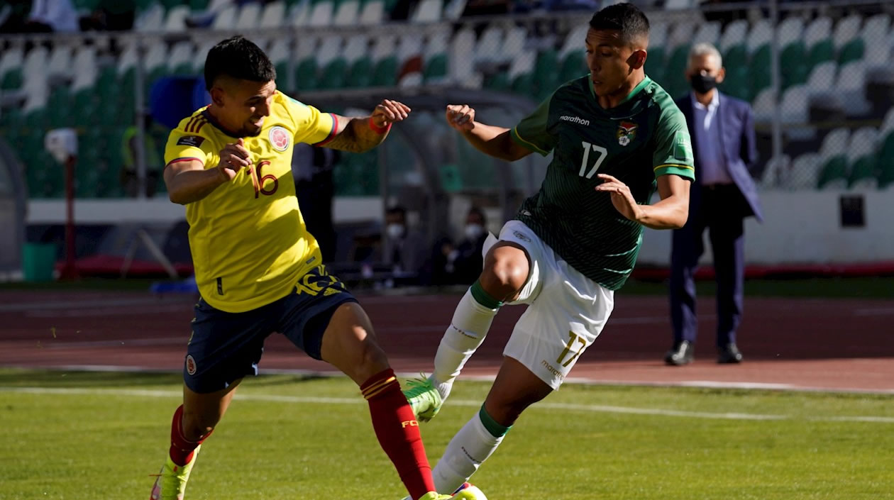 Daniel Muñoz disputando el balón con Roberto Fernández.