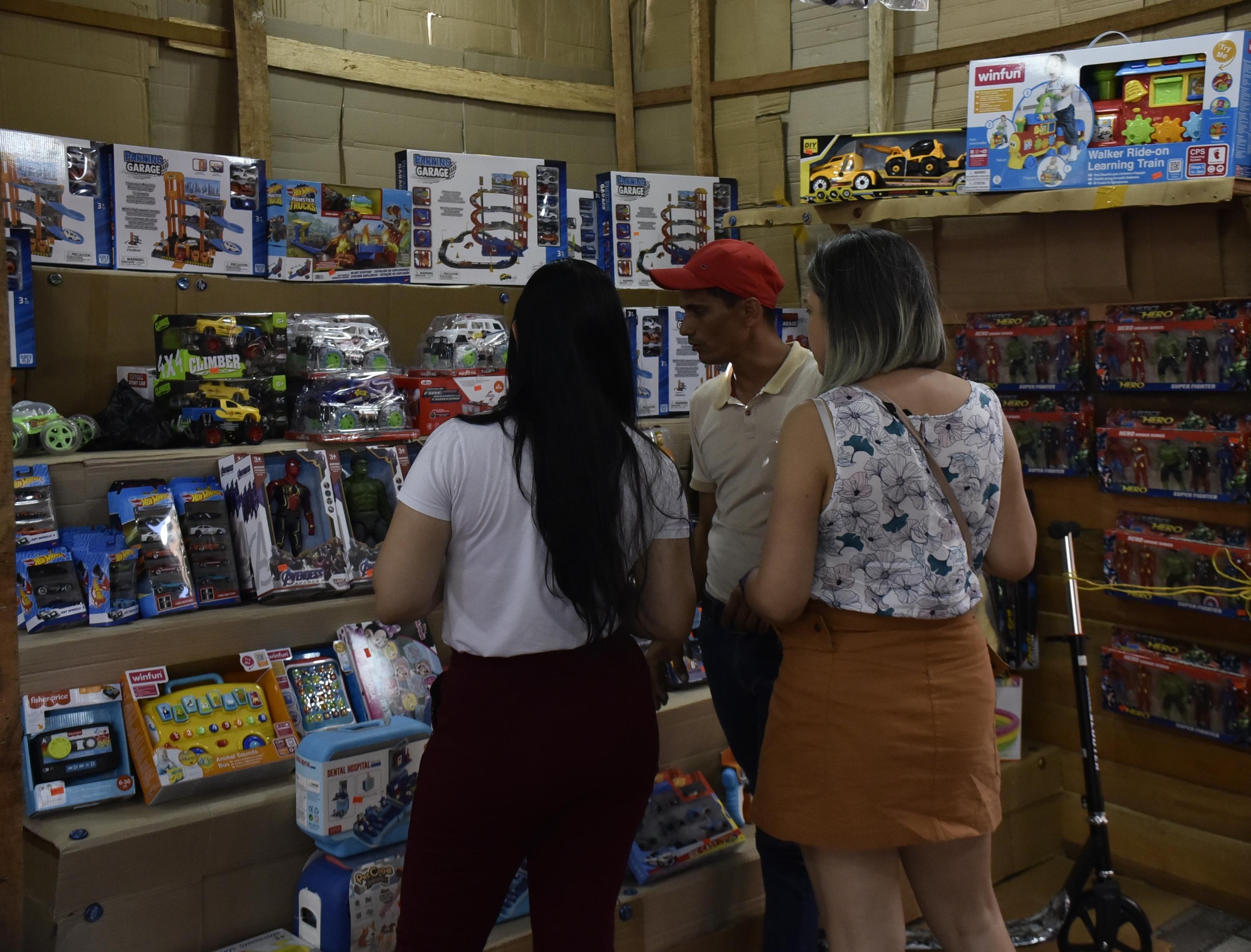 Ciudadanas observan unas pistas de carro en la Feria del Juguete.