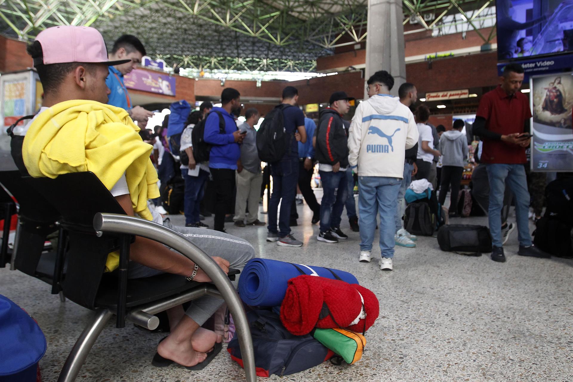 Un migrante espera la hora de tomar el bus. 