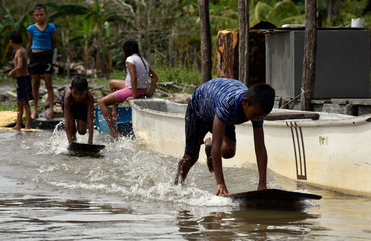 Los niños muestran su alegría surfeando en las olas de la Ciénaga Grande