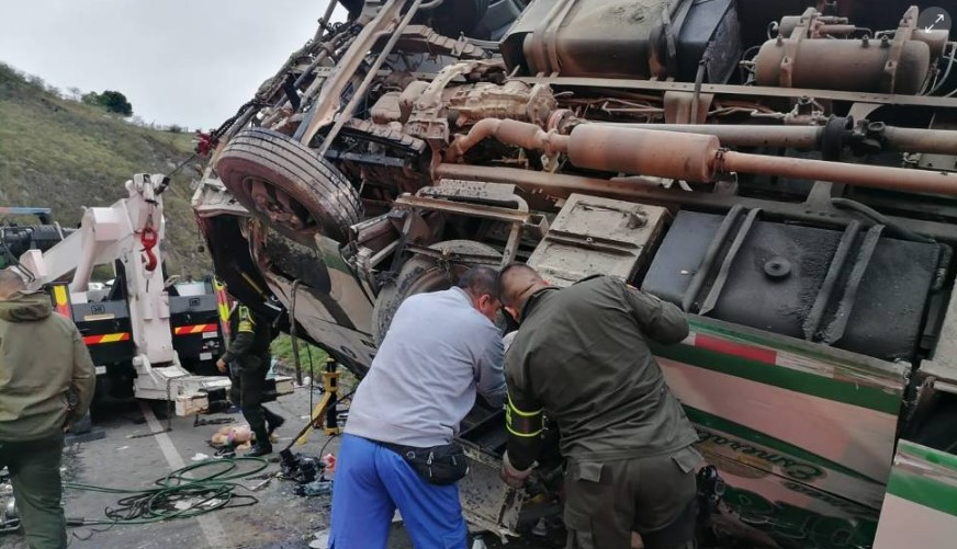 Varias personas revisan el bus de Transipiales accidentado el sábado en la noche.