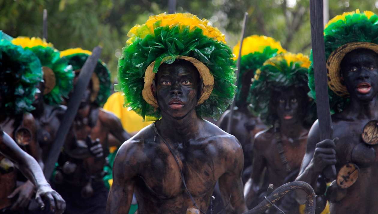 Bailarines actúan por las calles durante la celebración del Festival Son de Negros, en Santa Lucía.