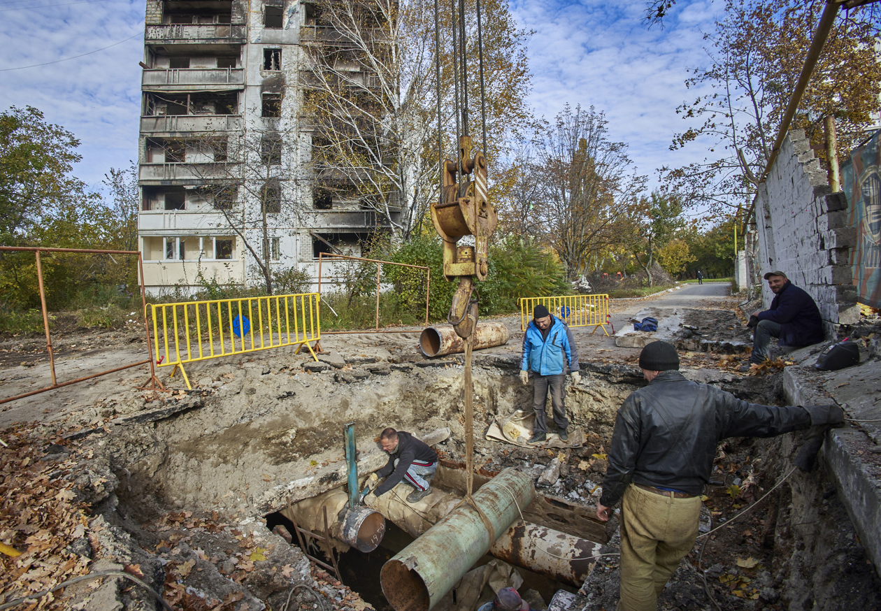 Trabajadores ucranianos reparan edificios.