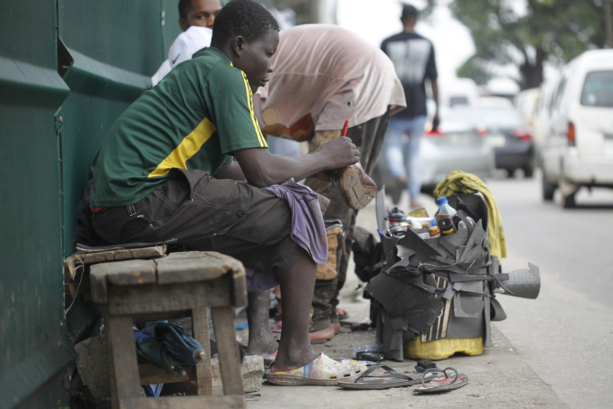 Zapateros reparan zapatos de cuero dañados en una calle de Lagos, Nigeria.