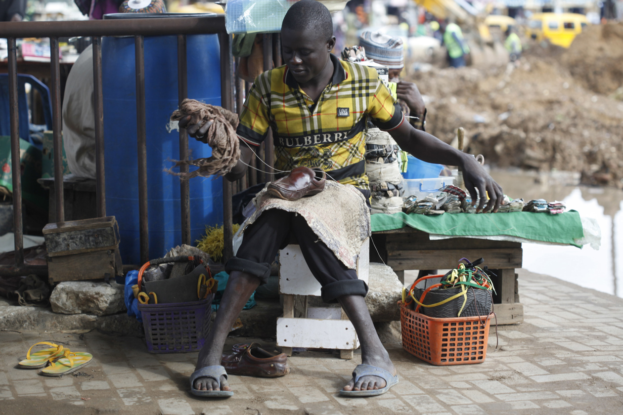 Zapateros reparan zapatos de cuero dañados en una calle de Lagos, Nigeria.