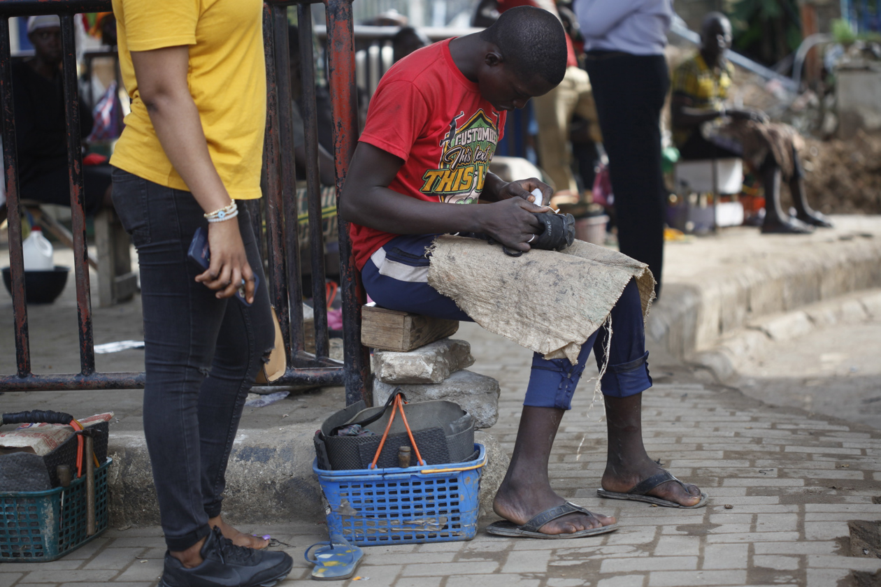 Zapateros reparan zapatos de cuero dañados en una calle de Lagos, Nigeria.
