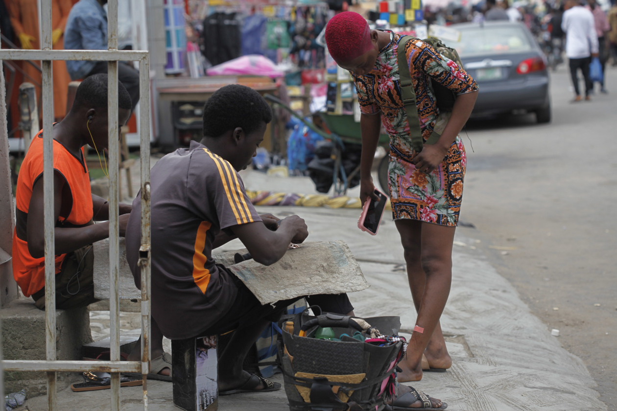 Zapateros reparan zapatos de cuero dañados en una calle de Lagos, Nigeria.