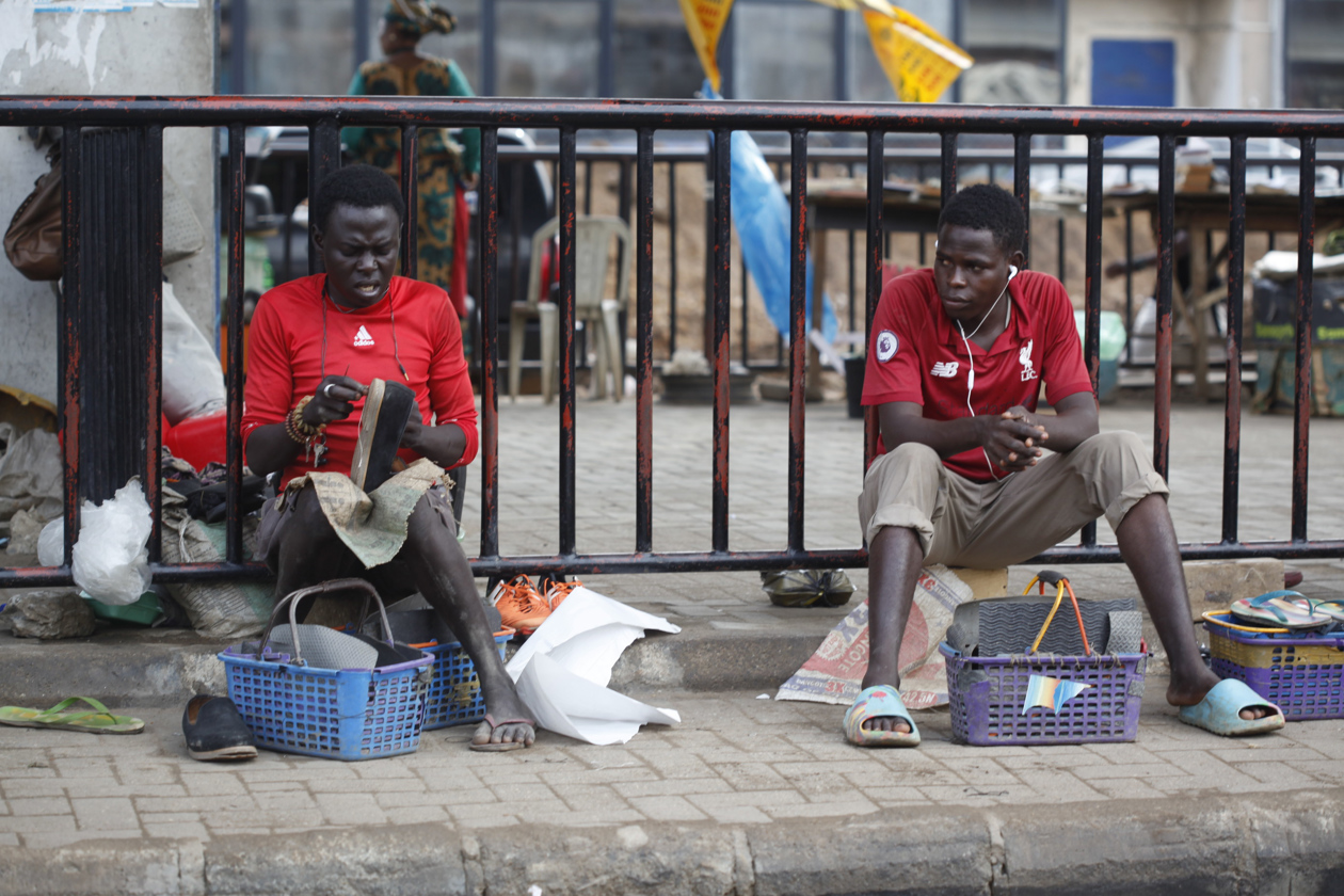 Zapateros reparan zapatos de cuero dañados en una calle de Lagos, Nigeria.