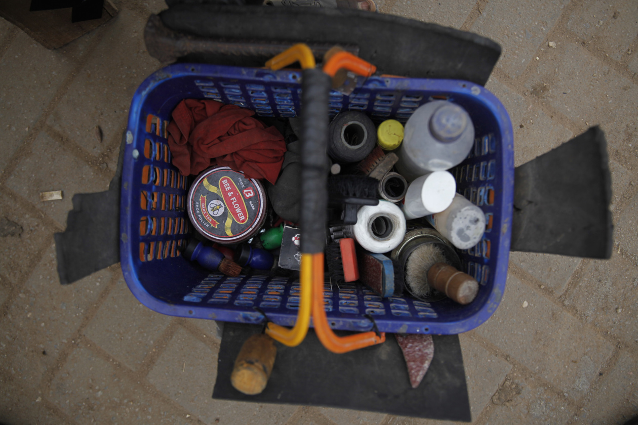 Zapateros reparan zapatos de cuero dañados en una calle de Lagos, Nigeria.