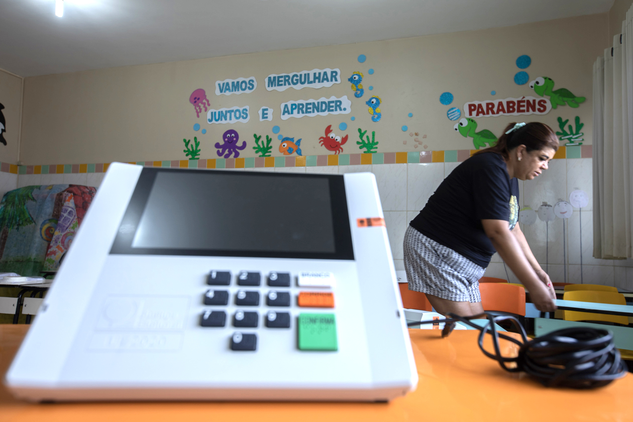 Una inspectora electoral instalando hoy una máquina de votación electrónica para las elecciones.