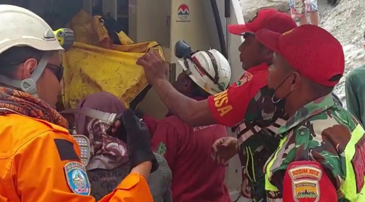 Rescatistas cargando el cuerpo de una víctima.