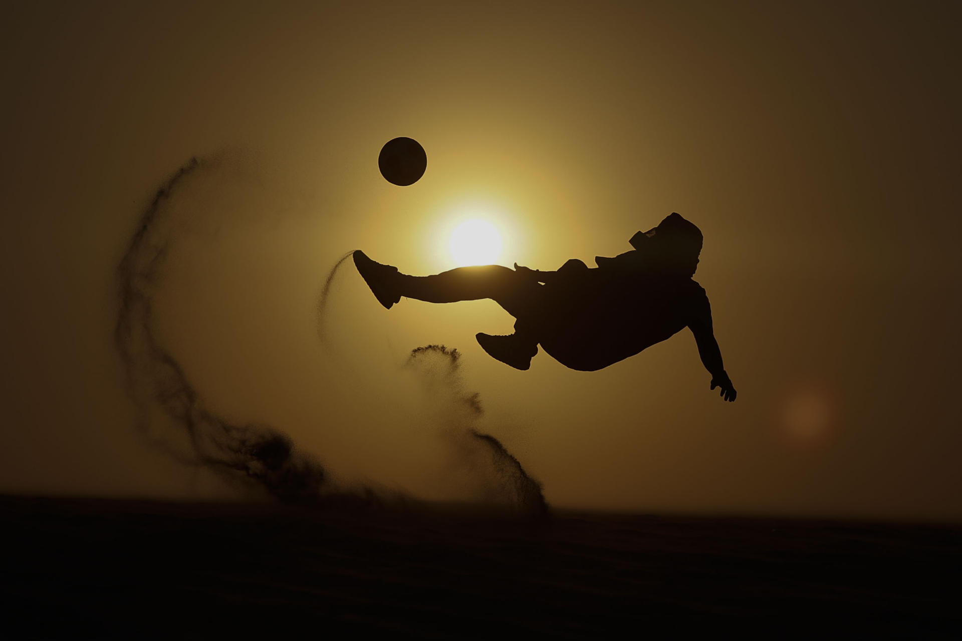 Un turista juega fútbol en el desierto. 