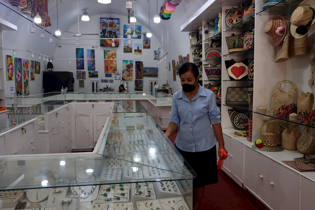 Una mujer limpia una vitrina de un almacén de recuerdos y artesanías para turistas, hoy, en Cartagena de Indias (Colombia). 