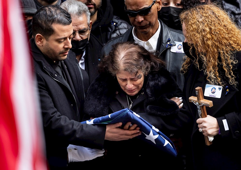 Los familiares del oficial de policía de la ciudad de Nueva York asesinado, Wilbert Mora, recibieron la bandera de su ataúd después de su funeral fuera de la Catedral de San Patricio en Nueva York.