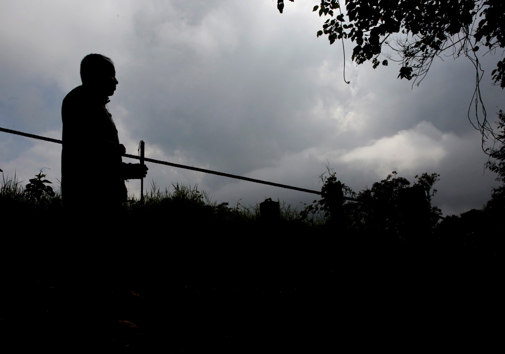 Un visitante camina guiándose por una línea de vida en la finca.
