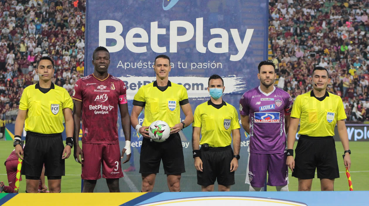 El cuarteto arbitral con los capitanes de los equipos.