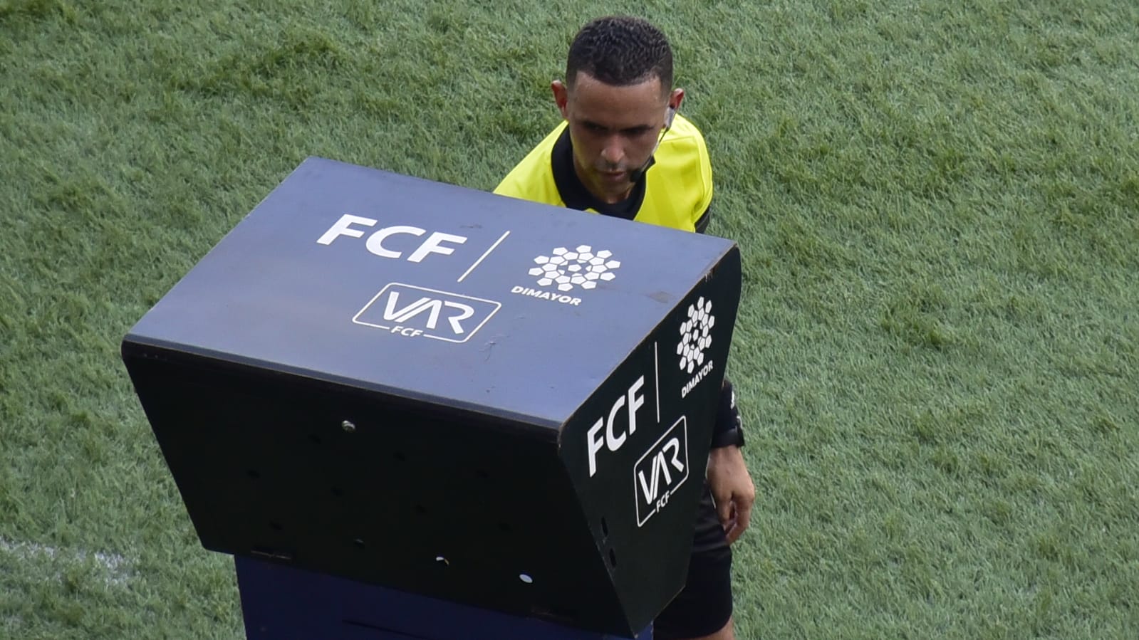 El árbitro Carlos Ortega revisando el VAR sobre posible penal.
