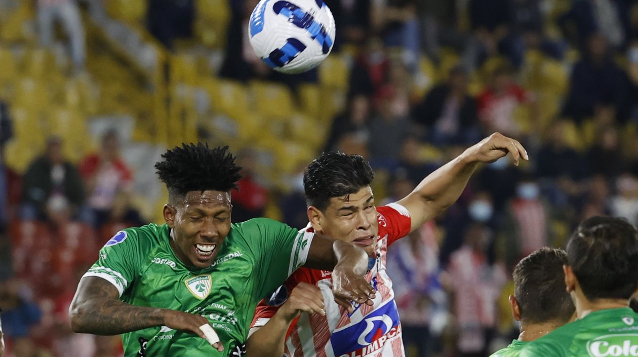 Joan Castro de La Equidad disputa un balón con Jorge Arias de Junior