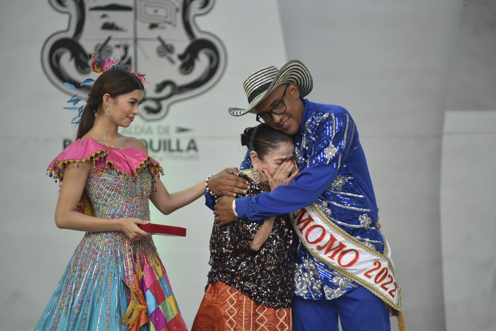 Un abrazo del Rey Momo, Kevin Torres, a la homenajeada Gloria Peña.