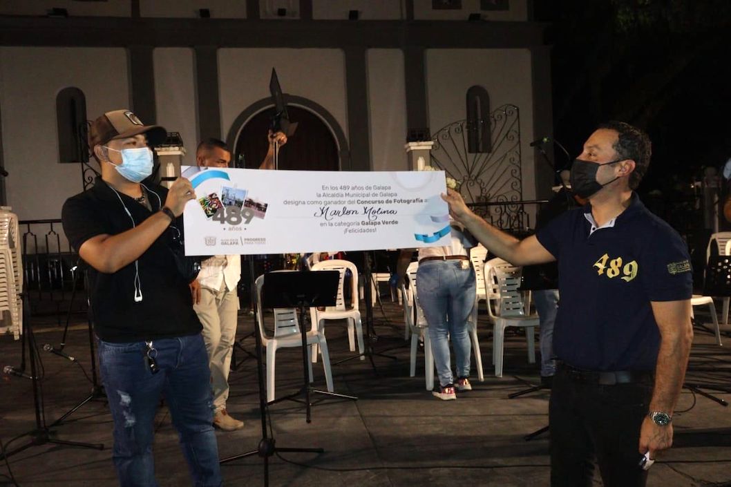 Premiación a uno de los ganadores del concurso de fotografía.