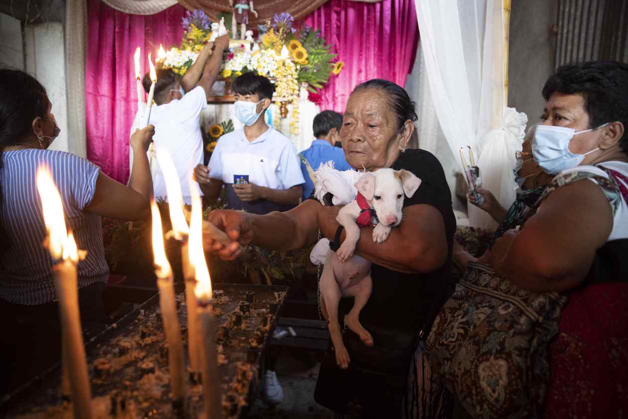 Una mujer carga su mascota durante una eucaristía en la iglesia Santa María Magdalena de Masaya (Nicaragua).