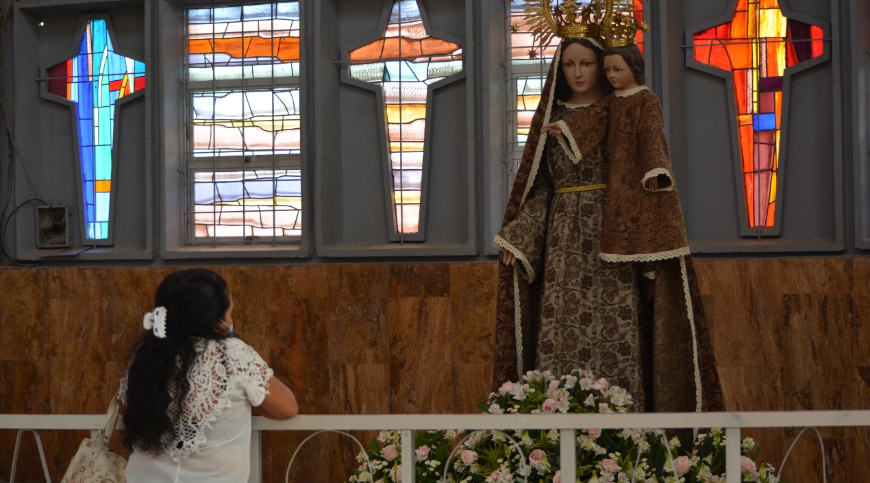 Una feligrés mira una imagen religiosa.
