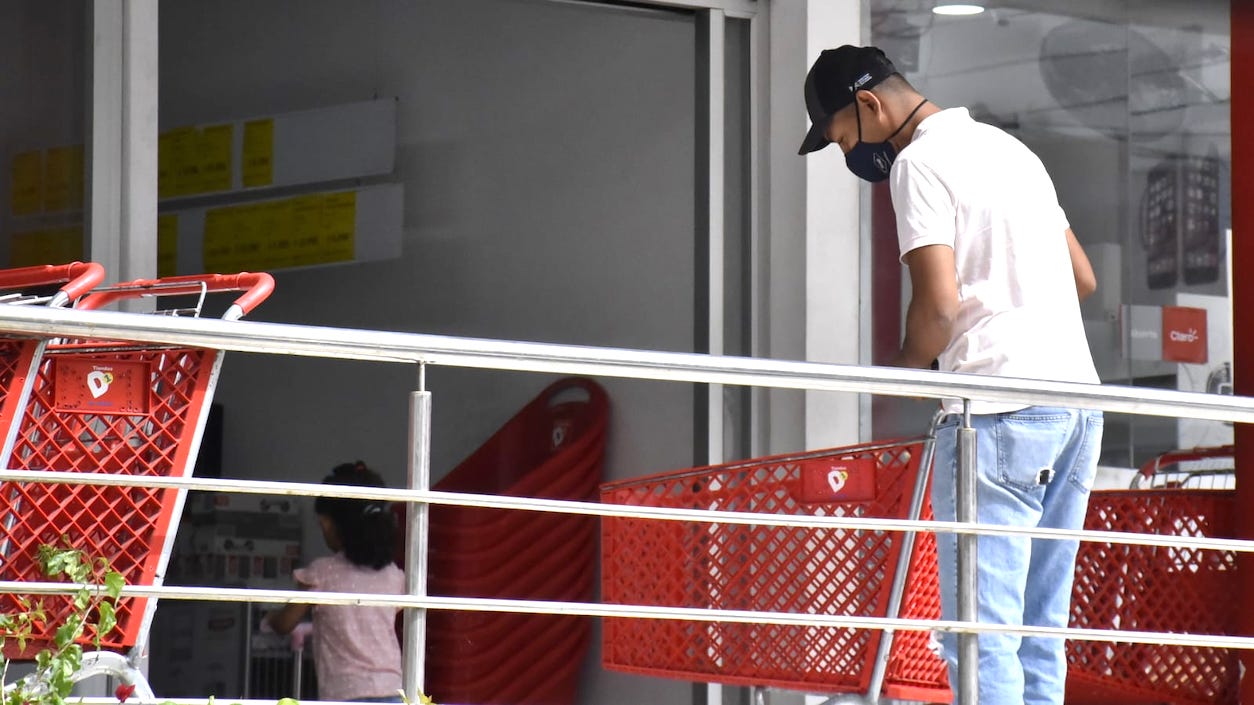 Un ciudadano con tapabocas ingresando a un establecimiento comercial.
