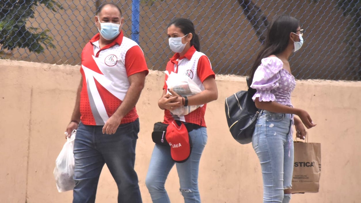 En la vía pública. utilizando el tapabocas.