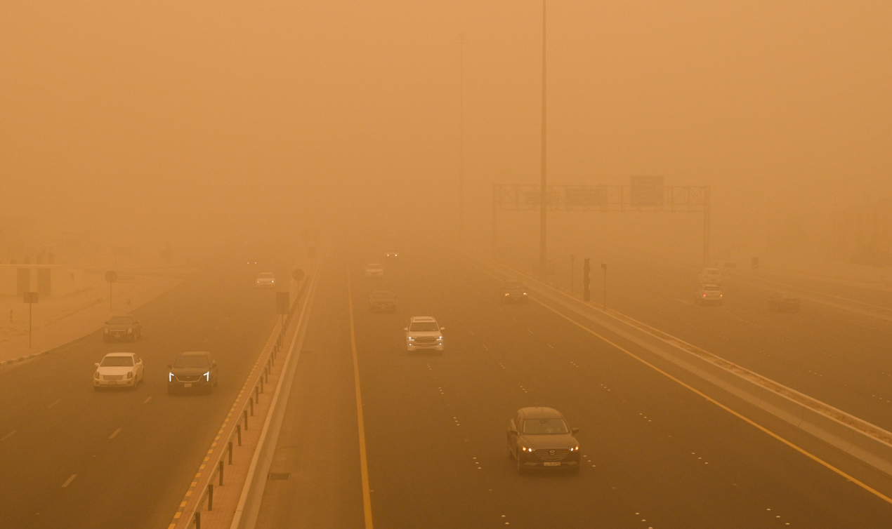 Los automóviles circulan en medio de una fuerte tormenta de polvo en la ciudad de Kuwait.