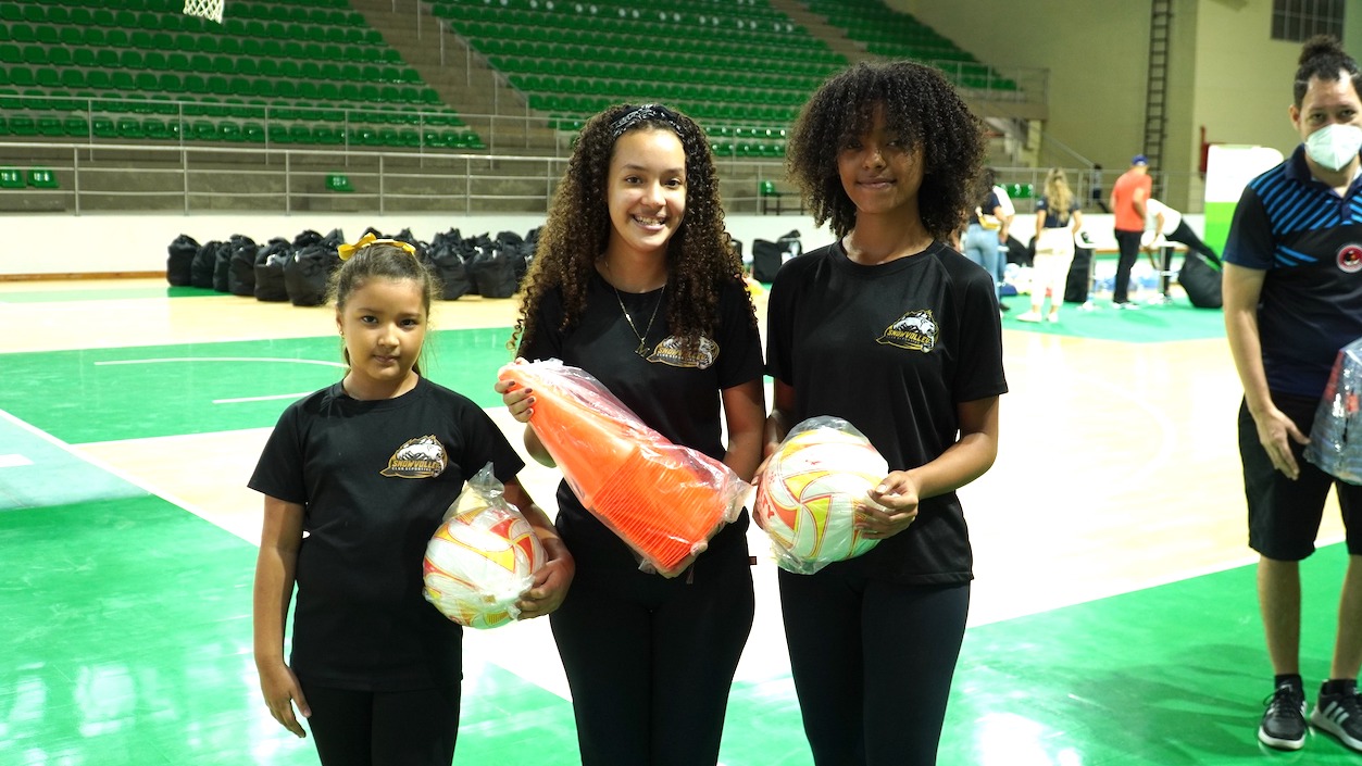 Jóvenes y niños recibiendo los implementos.