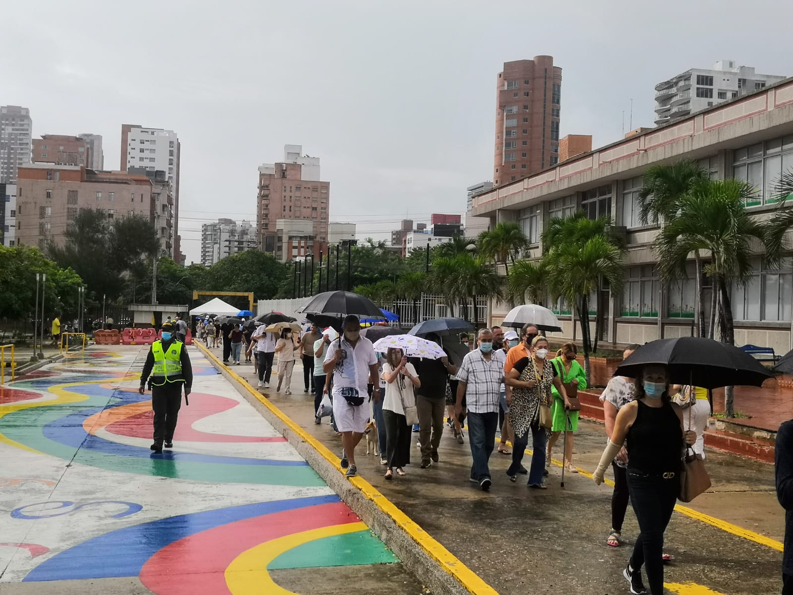 Fila de electores bajo llovizna