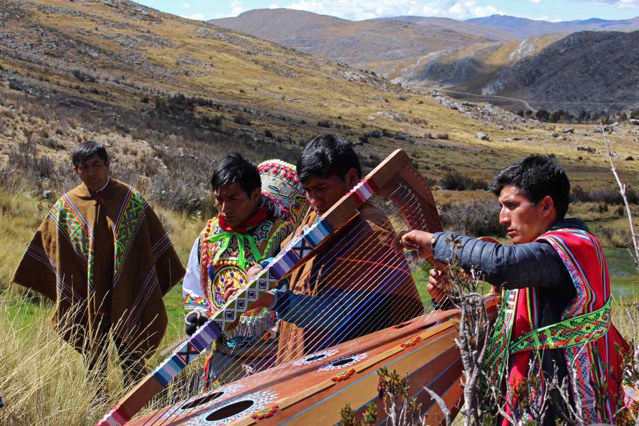 Músicos indígenas y campesinos acompañan un ritual de pago a la tierra durante las labores de "cría de agua"