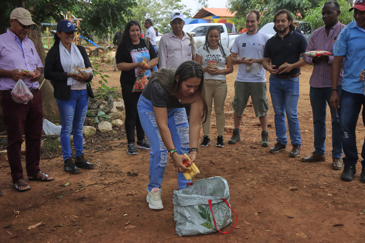 Una víctima del conflicto armado que deposita unos víveres en una bolsa, durante el acto de entrega y socialización del Informe Final de la Comisión de la Verdad que se realizó ante firmantes del Acuerdo de Paz con la guerrilla de las FARC y víctimas en el espacio territorial de Tierra Grata en San José de Oriente.