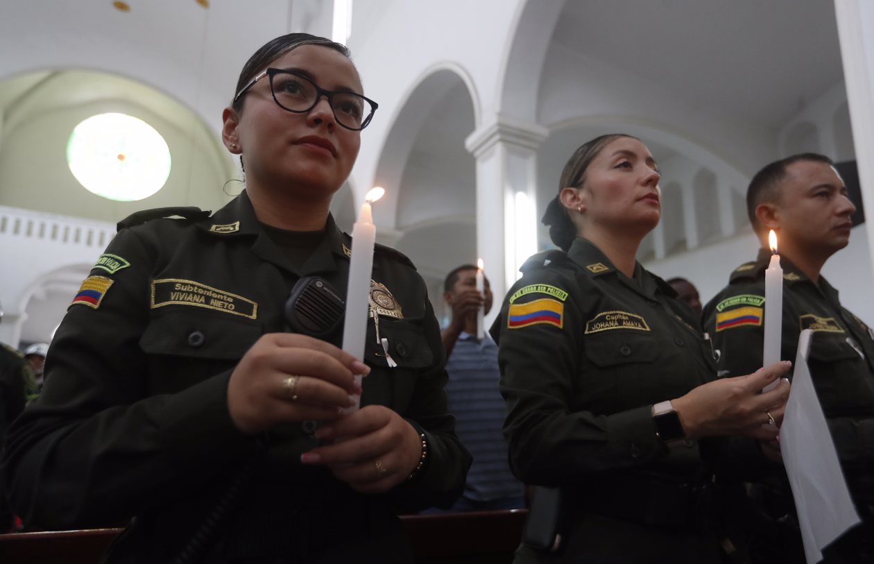 Policías participan en ceremonia religiosa en honor a sus compañeros asesinados recientemente en el país por el 'Clan del Golfo', en Cali.