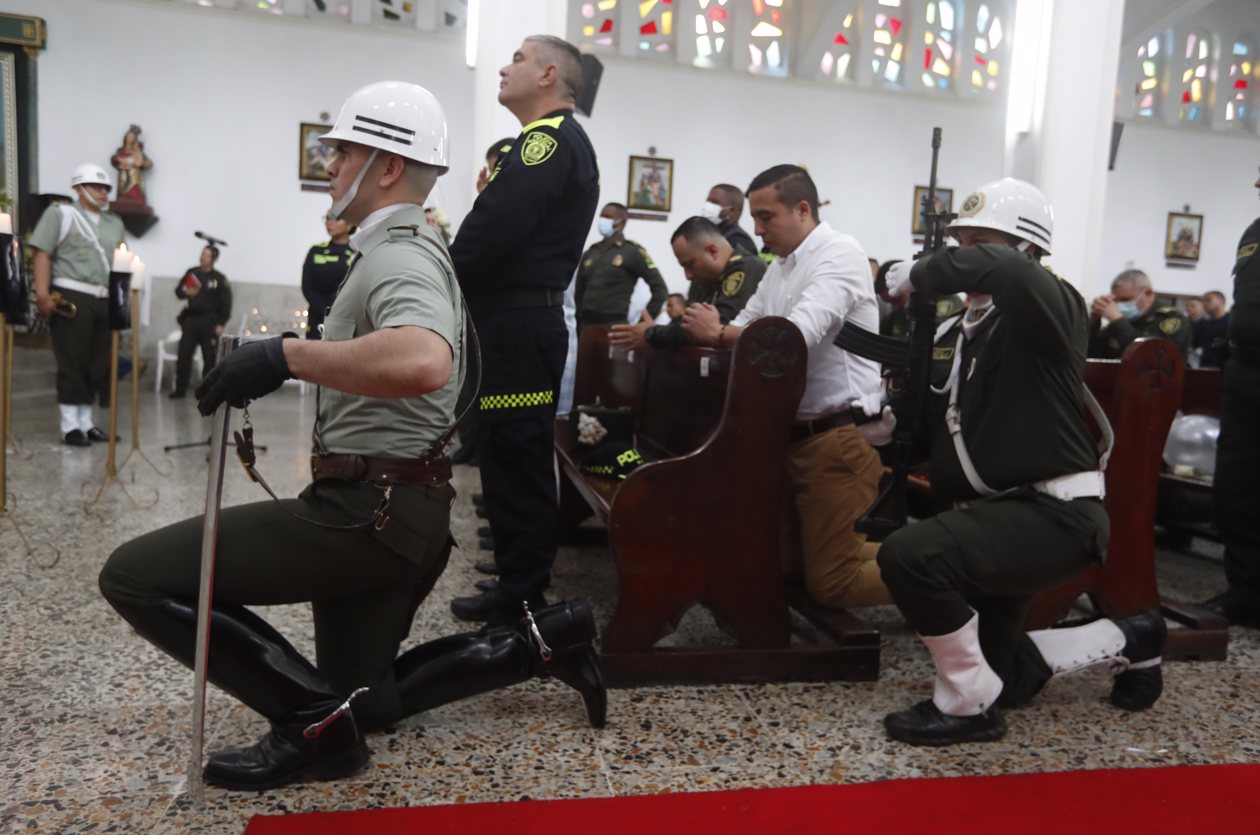 Policías participan en ceremonia religiosa en honor a sus compañeros asesinados recientemente en el país por el 'Clan del Golfo', en Cali.