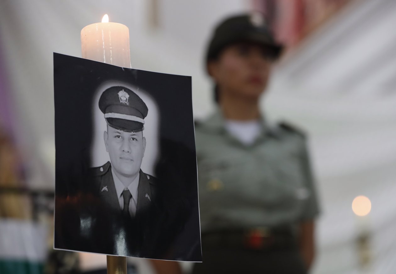 Vista de retratos durante ceremonia religiosa en honor a los policías asesinados recientemente en el país por el 'Clan del Golfo', en Cali.