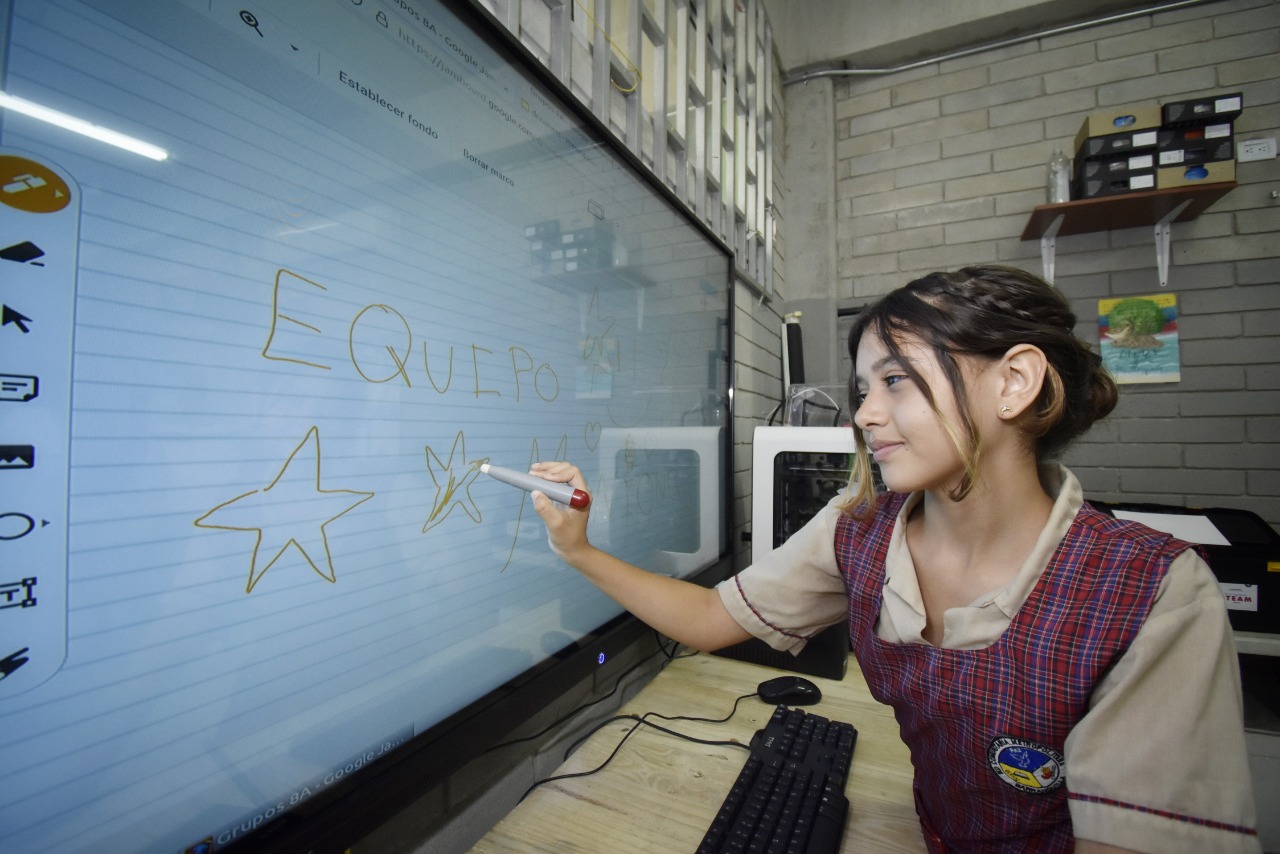 Estudiante probando la pantalla interactiva inteligente.