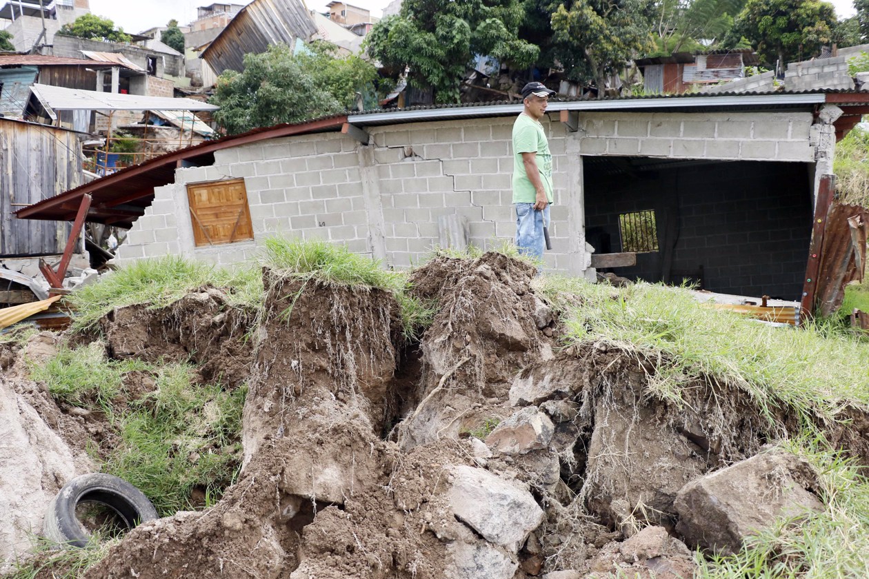 Personas tratan de rescatar sus pertenencias tras presentarse fallas estructurales en sus casas por las fuertes lluvias.