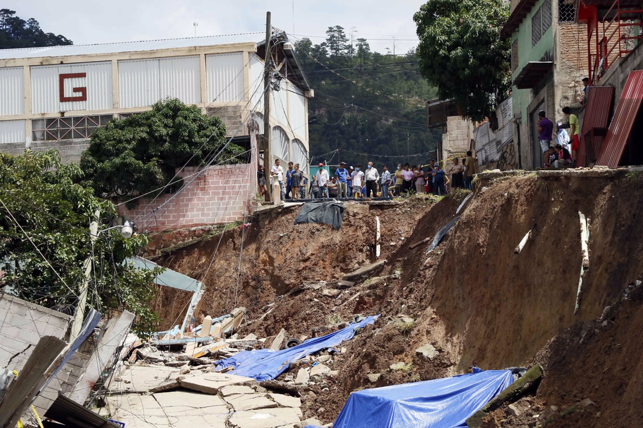 Personas tratan de rescatar sus pertenencias tras presentarse fallas estructurales en sus casas por las fuertes lluvias.