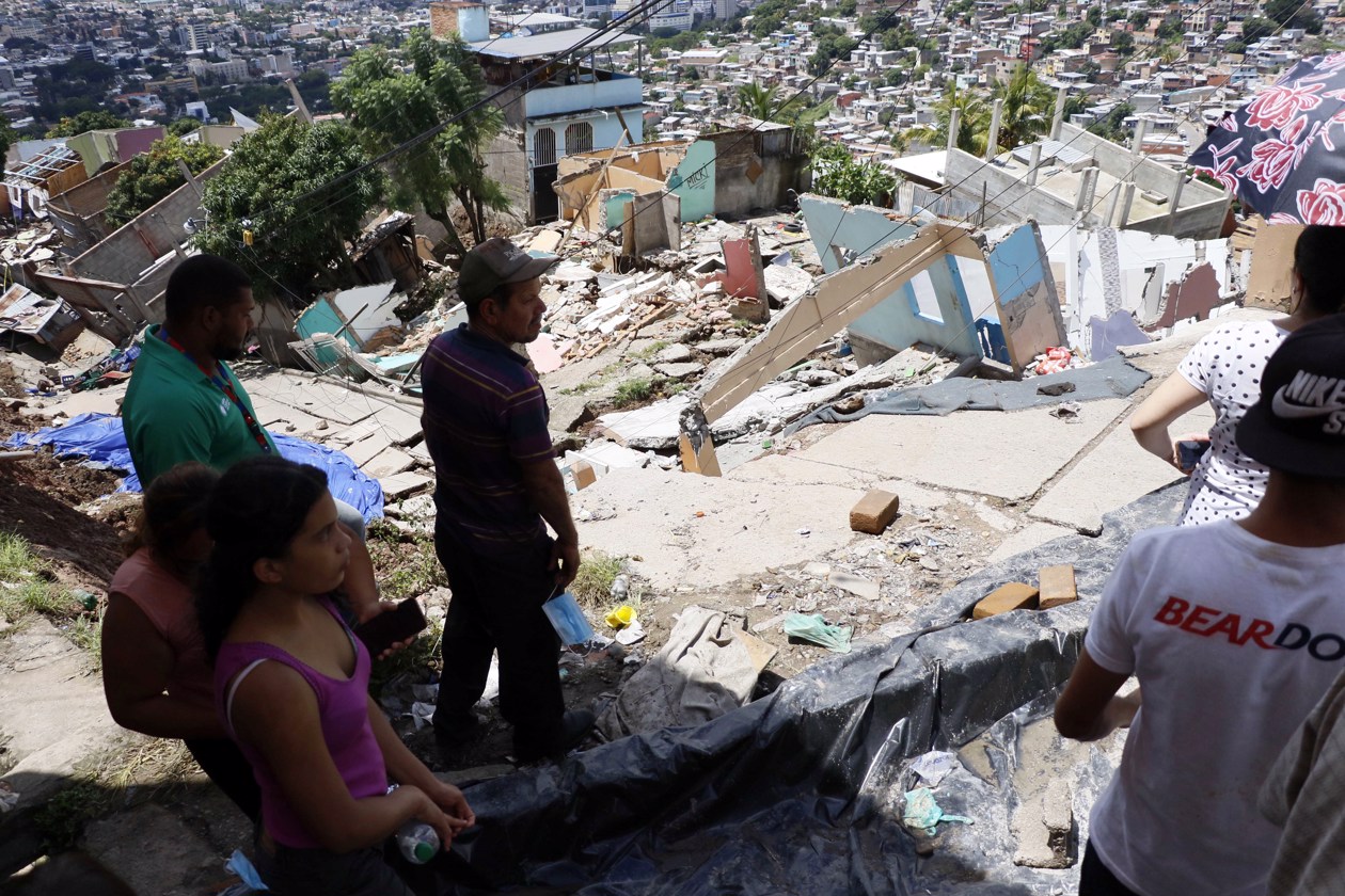 Personas tratan de rescatar sus pertenencias tras presentarse fallas estructurales en sus casas por las fuertes lluvias.