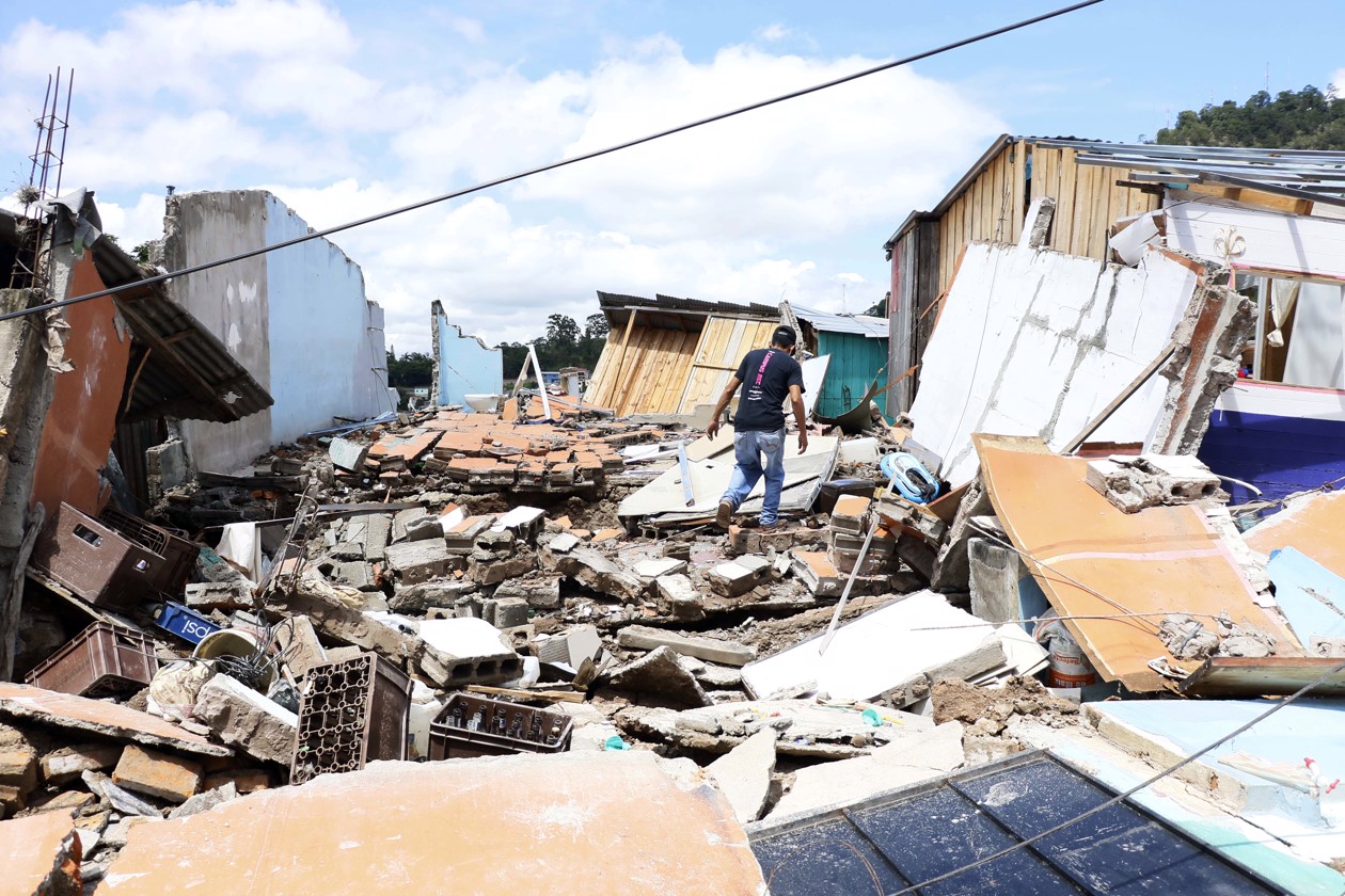 Personas tratan de rescatar sus pertenencias tras presentarse fallas estructurales en sus casas por las fuertes lluvias.